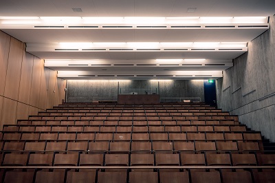 A big auditorium with bench rows and a projector in the back.